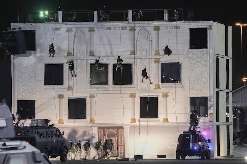 Special forces abseil down a building at the parade. AP