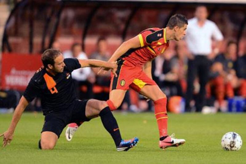 Belgium's Kevin Mirallas evades Holland's Joris Mathijsen during a friendly in Brussels.