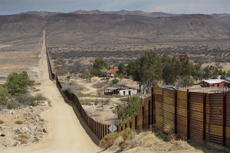 TOPSHOT - Houses are seen on the Mexican side of the US/ Mexico border fence on April 6, 2018 in Jacumba, California. 
US President Donald Trump on April 5, 2018 said he would send thousands of National Guard troops to the southern border, amid a widening spat with his Mexican counterpart Enrique Pena Nieto. The anti-immigration president said the National Guard deployment would range from 2,000 to 4,000 troops, and he would "probably" keep many personnel on the border until his wall is built -- spelling out a lengthy mission.
 / AFP PHOTO / Sandy Huffaker