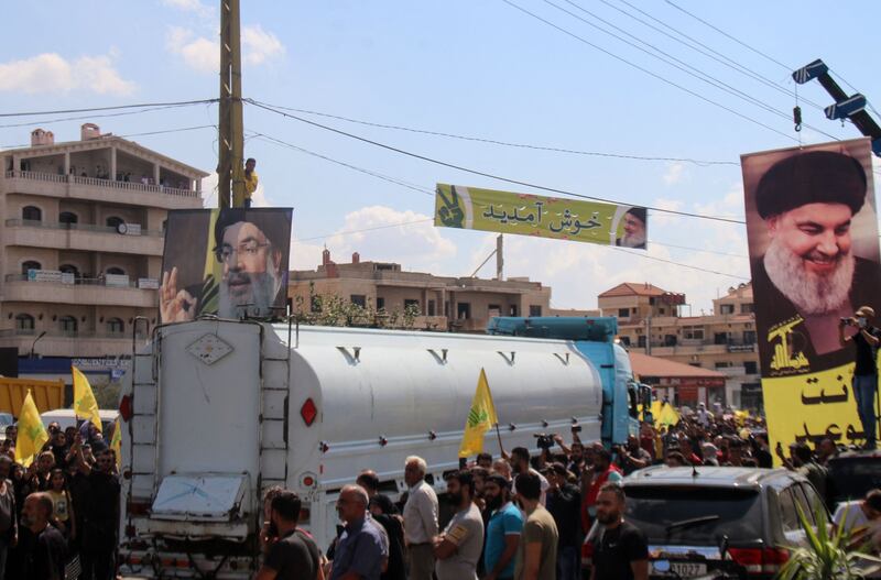 Hezbollah supporters with posters of the Shiite movement's leader Hassan Nasrallah as they gather to welcome tankers carrying Iranian fuel. AFP