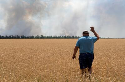 A farmer watches as wheat fields are burnt by fighting in the Dnipropetrovsk region of Ukraine. AP 