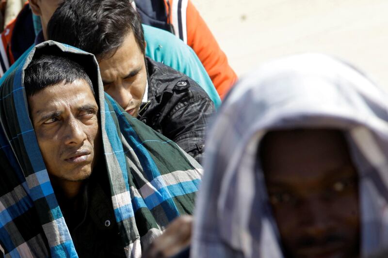 Migrants sit at a naval base after they were rescued by Libyan coastguard, in Tripoli, Libya October 18, 2017. REUTERS/Ismail Zitouny