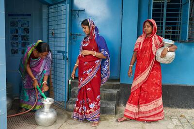 Women collect water at a reverse osmosis plant at Borokuput, Bangladesh. Photo: WaterAid