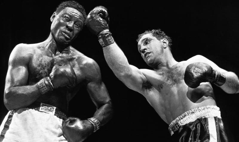 Champion Rocky Marciano scores with a solid right uppercut to head of challenger Ezzard Charles in their Heavyweight title bout in the yankee Stadium, New York, on June 17, 1954, in which Marciano retained his title. Marciano?s left eye shows deep cut sustained earlier in bout during the eighth round. (AP Photo)