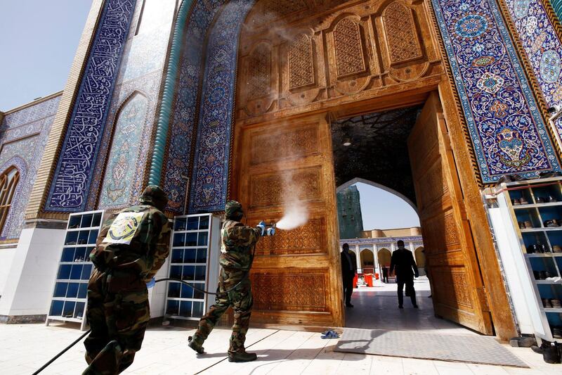 Members of the civil defence team spray disinfectant at the Kufa mosque in Najaf. Reuters