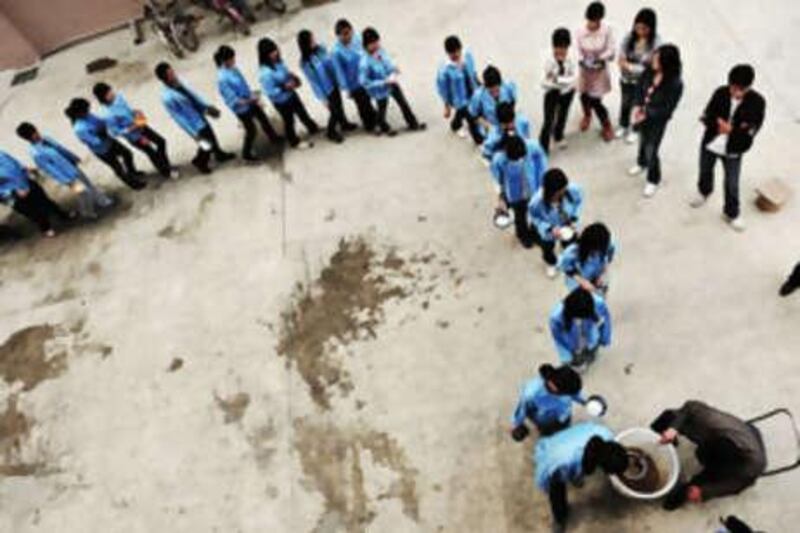 Major illness can "push people into poverty" in poorer areas, as insurance schemes often only pay a percentage of treatment costs. Above, workers from a company queue to receive food in Shenzhen, Guangdong Province, last year.