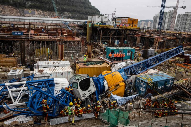 Members of the Urban Search And Rescue team work on a collapsed crane in Hong Kong, where two people died and six were injured at a construction site. AFP