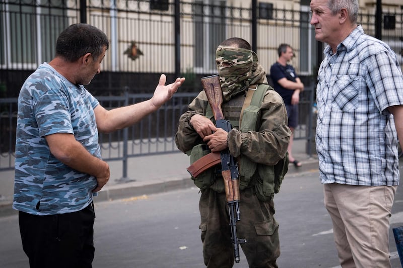 Rostov-on-Don residents speak with a Wagner fighter. AFP