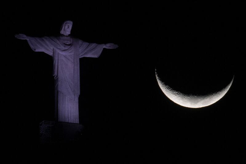 The crescent moon alongside the Christ he Redeemer statue in Rio de Janeiro, Brazil. AFP