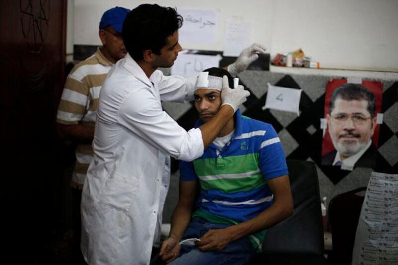 A medic treats a wounded supporter of deposed Egyptian President Mohamed Mursi at a local hospital in Cairo July 8, 2013.  REUTERS/Suhaib Salem (EGYPT - Tags: POLITICS CIVIL UNREST)