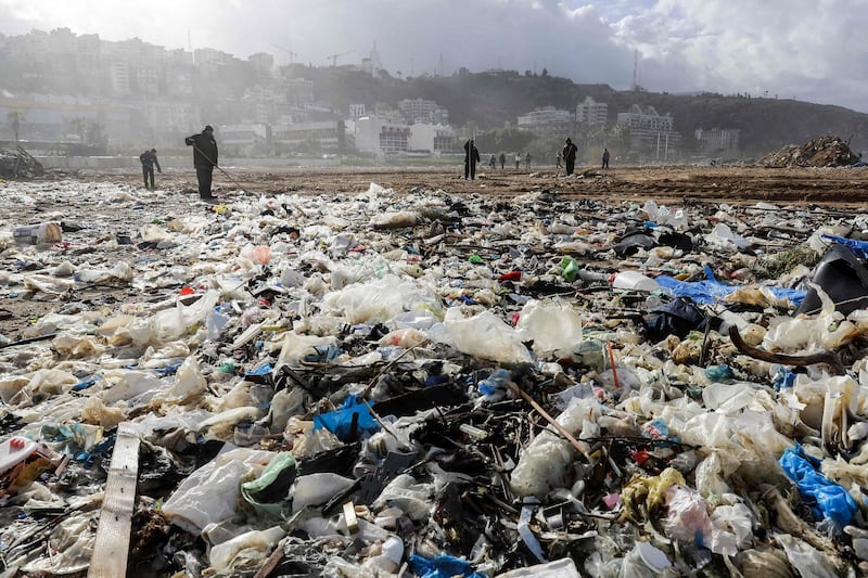 (FILES) In this file photo taken on January 23, 2018, workers clean the beach of the coastal town of Zouk Mosbeh, north of Beirut, as garbage washed and piled along the shore after stormy weather. Four years after a trash crisis sparked political protests in Lebanon, the garbage stench is back and government efforts to address it have sparked demands for better waste management. In the Beirut suburb of Bourj Hammoud, a seaside landfill that reopened to solve the 2015 crisis will be full by the end of the summer.
 / AFP / JOSEPH EID
