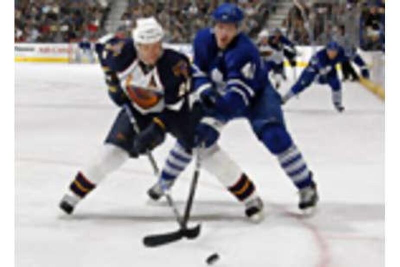 Nikolai Kulemin, right, of the Toronto Maple Leafs battles for the puck with Niclas Havelid, left, of the Atlanta Thrashers.
