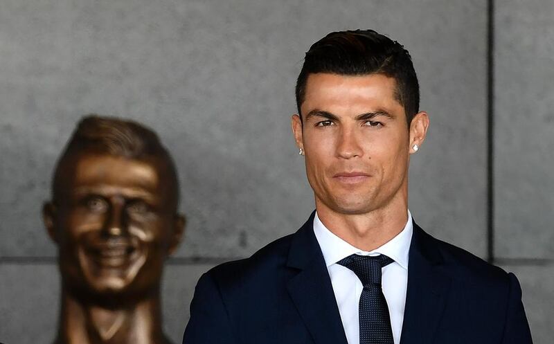Portuguese footballer Cristiano Ronaldo stands next to a bust of himself presented during the renaming ceremony for Madeira's international airport in Funchal. Francisco Leong / AFP