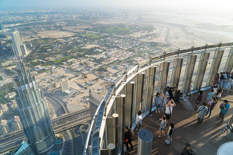 HHMJ7D Tourists meet sunrise at the observation deck on the 125 floor of Khalifa tower. Alamy