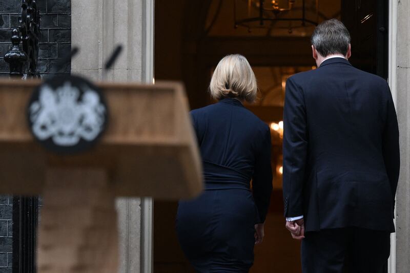 Liz Truss and her husband Hugh O'Leary walk back inside 10 Downing Street following her resignation statement. AFP