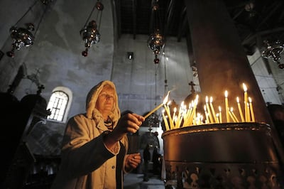 A tourist lights a candle at the Church of Nativity, revered as the site of Jesus’ birth, ahead of Christmas in the West Bank town of Bethlehem. Reuters