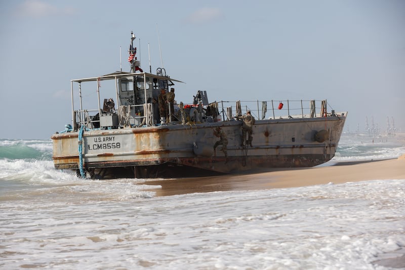 Troops work on a beached vessel, used for delivering aid to Palestinian, after it got stuck trying to help another vessel behind it.  Reuters