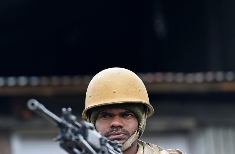 An Indian paramilitary trooper stands guard on top of am armoured vehicle inside a polling station during the last phase of urban local body polls, on the outskirts of Srinagar. AFP