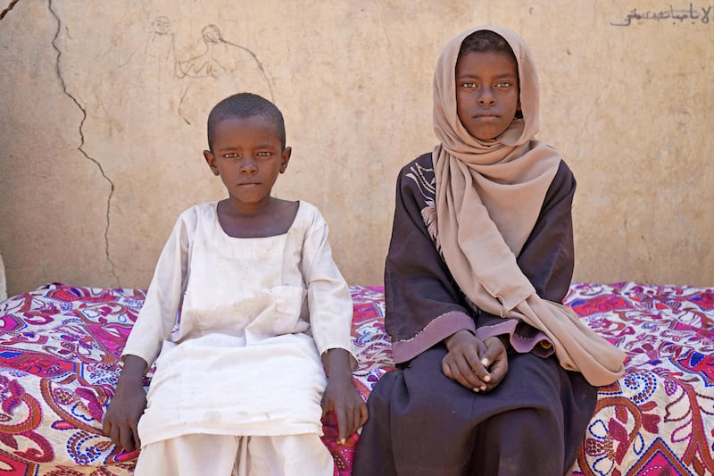 Zahra Hussein (R), a nine-year-old Sudanese girl who dropped out of school for financial reasons, poses for a picture with her brother at their home in the village of Ed Moussa in Sudan's eastern state of Kassala, on September 27, 2022.  - There are nearly seven million children in Sudan who no longer go to school, a victim of what aid agencies have warned is a "generational catastrophe".  Children in the country have for years faced mounting difficulties gaining access to proper education, especially in rural areas.  Sudan is already one of the world's poorest countries, plagued by political instability, droughts, hunger and conflict, with an adult literacy rate of only around 60 percent according to the World Bank.  AFP