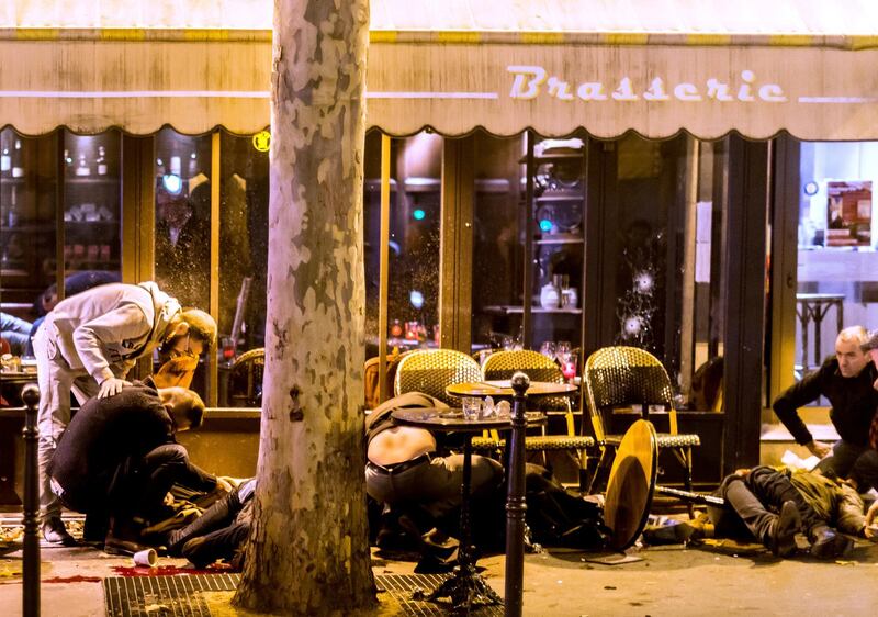 People lie on the pavement at the terrace of the cafe "A la Bonne Biere" in Paris, on November 13, 2015, following a series of coordinated attacks in and around Paris which left more than 120 people dead. AFP PHOTO / ANTHONY DORFMANN / AFP PHOTO / Anthony DORFMANN