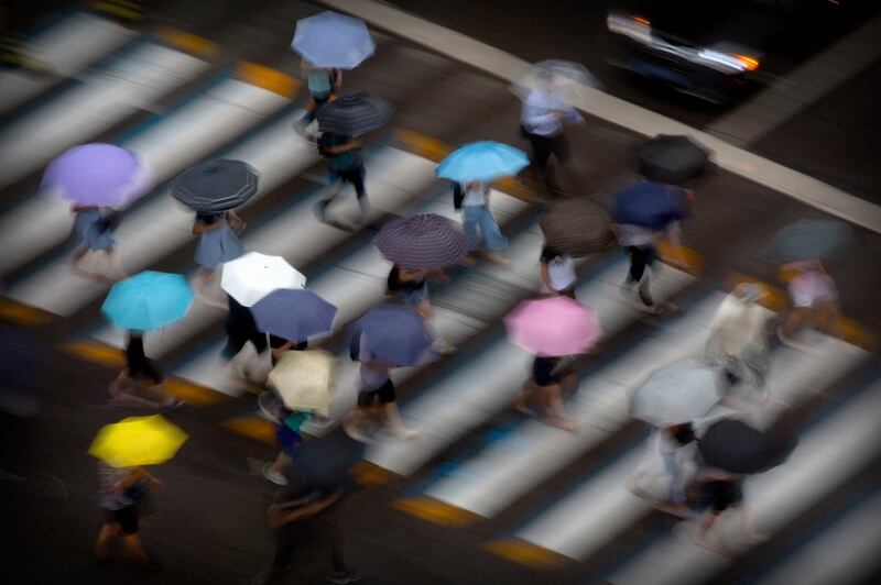 Pedestrians carry umbrellas in Beijing. AP Photo