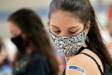 Kent State University student Regan Raeth of Hudson, Ohio, looks at her vaccination bandage as she waits for 15 minutes after her shot in Kent, Ohio. AP Photo