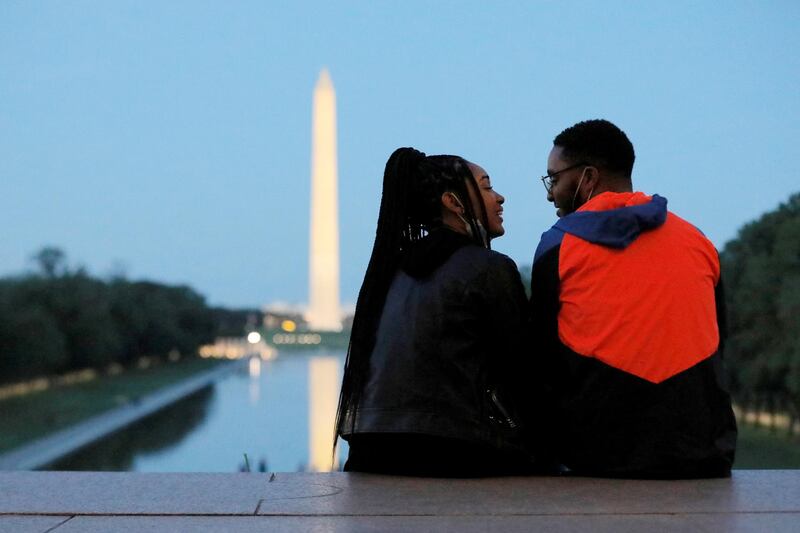 A couple sit on the steps of the Lincoln Memorial looking toward the Washington Monument in Washington, US. Reuters