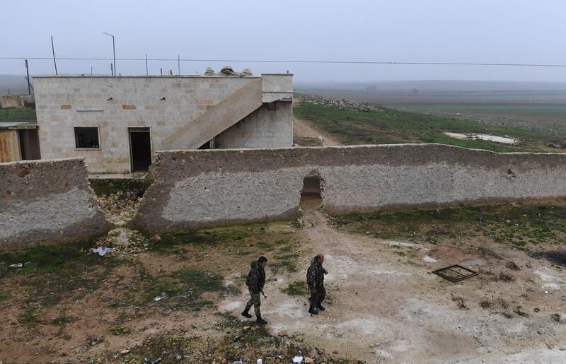 Members of the Syrian regime forces walk near buildings in the southern countryside of the northern Kurdish-controlled city of Manbij.  The unexpected US pullout announcement left Syria's Kurds scrambling to find a new ally in the Damascus regime, as they feared losing US support would leave them exposed to a long-threatened Turkish assault. AFP