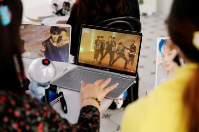 Fans of K-pop idol boy band BTS watch a live streaming online concert, wearing a protective masks to avoid the spread of the coronavirus disease (COVID-19), at a cafe in Seoul, South Korea October 10, 2020.    REUTERS/Heo Ran