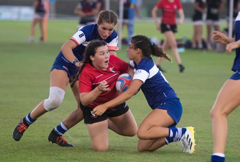 JESS players in blue tackle a Dubai English Speaking College player during the girls' U12 final. Ruel Pableo for The National