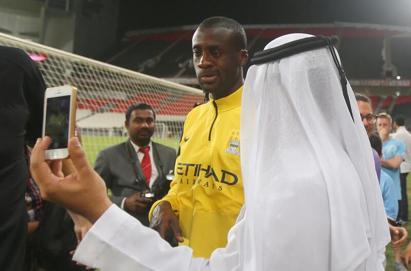 An Emirati fan takes a ‘selfie’ with Manchester City player Yaya Toure during the training session. Marwan Naamani / AFP