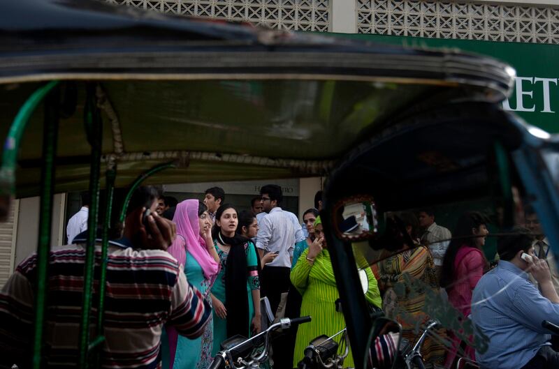 People evacuate buildings and gather on road after a tremor of an earthquake was felt in Karachi, Pakistan, Tuesday, April 16, 2013. A major earthquake described as the strongest to hit Iran in more than half a century flatted homes and offices Tuesday near Iran's border with Pakistan, killing at least tens of people in the sparsely populated region and swaying buildings as far away as New Delhi and the skyscrapers in Dubai and Bahrain. (AP Photo/Shakil Adil) *** Local Caption ***  APTOPIX Pakistan Quake.JPEG-0f348.jpg