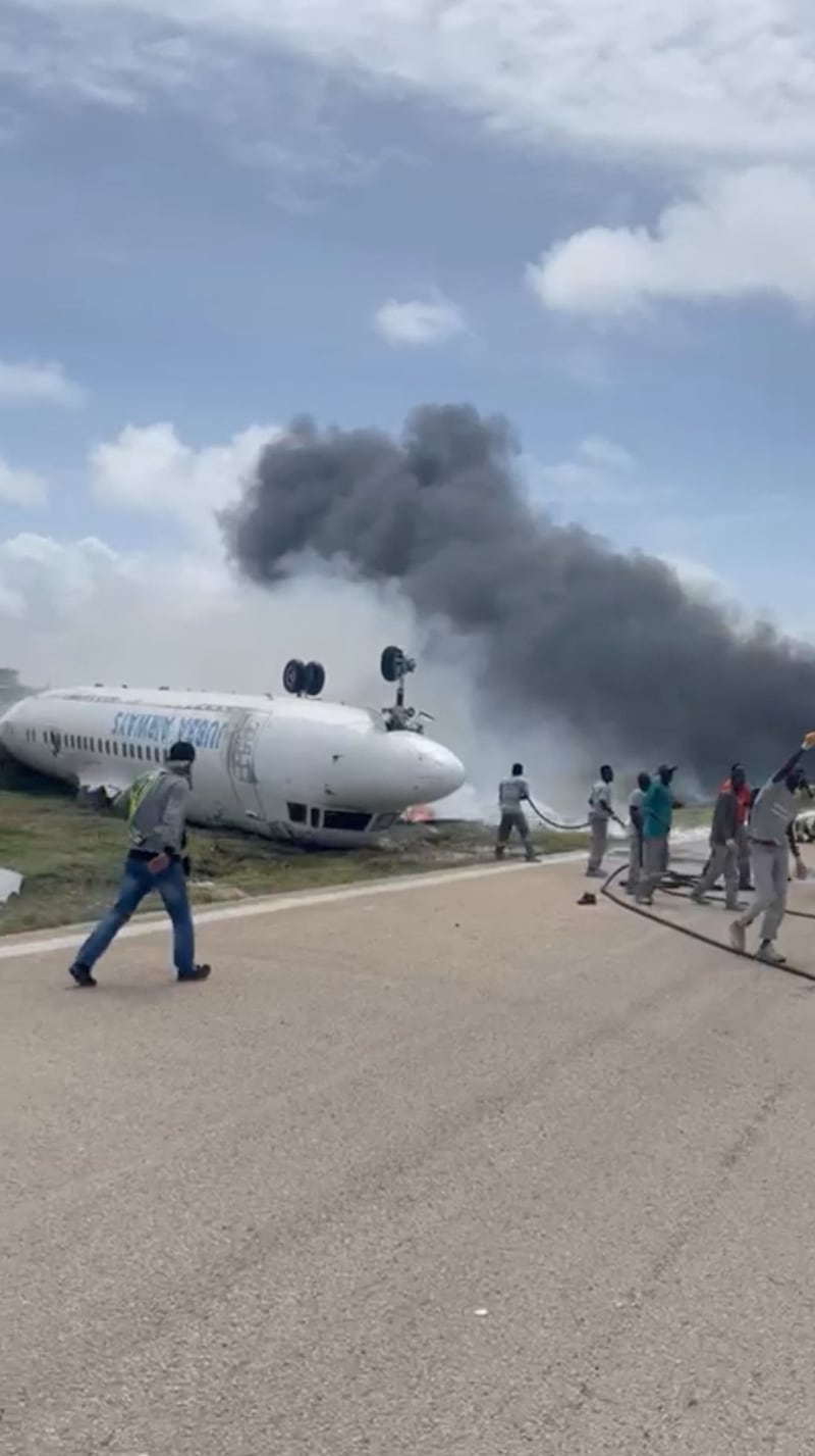 Smoke billows from a plane that flipped over after a crash landing, in Mogadishu, Somalia in this picture obtained from social media. Photo: Abdirahman Mohamed Arab via Reuters