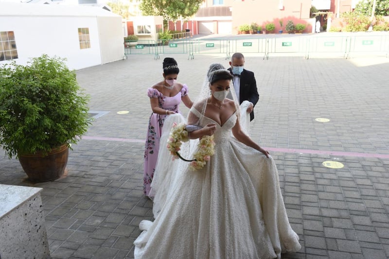 Laura Daher takes a moment before she walks into the church with her sister and maid of honor Linda and brother George for her wedding a small service at St Therese Church in Abu Dhabi on August 17 following safety rules amid the coronavirus pandemic. Courtesy: Laura Daher and Elie Abi Daher