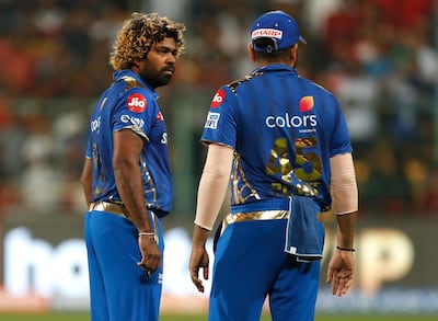 In this, Thursday, March 28, 2019 photo, Mumbai Indians' bowler Lasith Malinga, left, interacts with captain Rohit Sharma before bowling the last delivery during the VIVO IPL T20 cricket match between Royal Challengers Bangalore and Mumbai Indians in Bangalore, India. Mumbai Indians won by six runs. (AP Photo/Aijaz Rahi)
