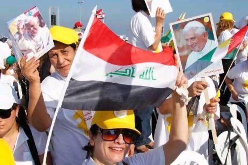 Christians hold up Iraqi and Kurdish national flags, along with Pope Benedict XVI pictures, upon his arrival in Beirut to conduct an open-air Mass.