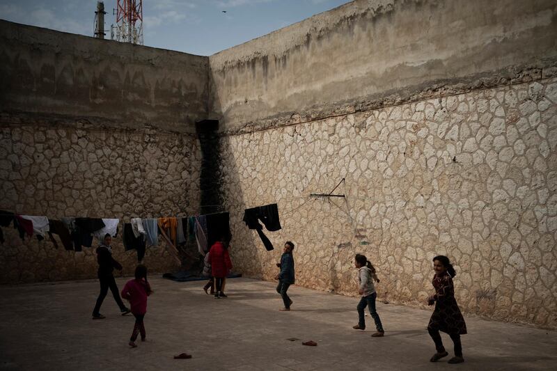 In this Thursday, March 12, 2020 photo, children play inside Idlib's old central prison, now transformed into a camp for people displaced by fighting, in Idlib, Syria. Idlib city is the last urban area still under opposition control in Syria, located in a shrinking rebel enclave in the northwestern province of the same name. Syriaâ€™s civil war, which entered its 10th year Monday, March 15, 2020, has shrunk in geographical scope -- focusing on this corner of the country -- but the misery wreaked by the conflict has not diminished. (AP Photo/Felipe Dana)
