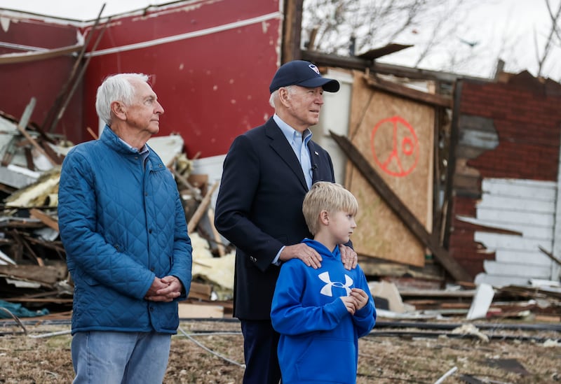 Mr Biden, centre, stands with former Kentucky governor Steve Beshear, left, and Dane Maddox as he inspects damage from a tornado that struck the state on December 10. EPA