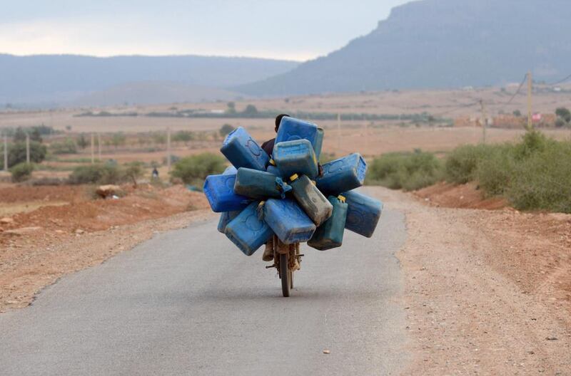 A man on a motorcycle in Oujda, near Morocco’s Mediterranean coast, carries empty barrels into Algeria to fill with oil and smuggle back into Morocco. Fadel Senna / AFP