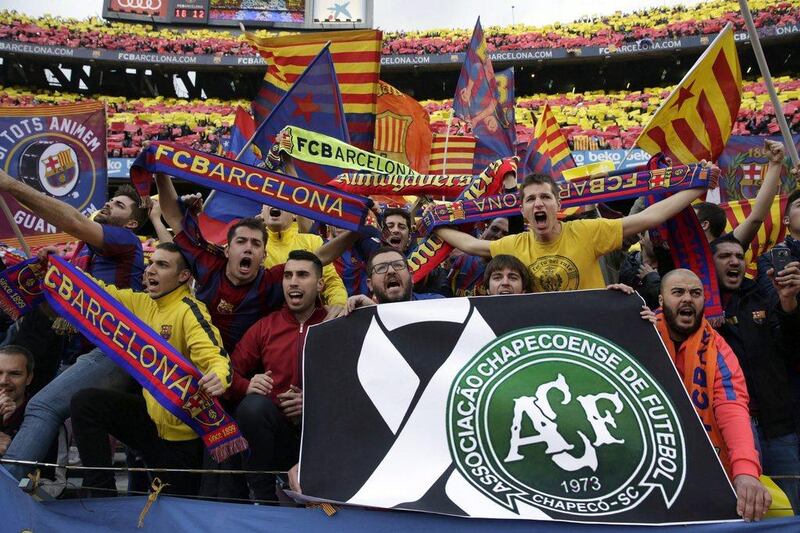 FC Barcelona fans cheer for their team and hold a sign honouring Chapecoense prior to the clasico at the Camp Nou last weekend. Alberto Estevez / EPA / December 3, 2016