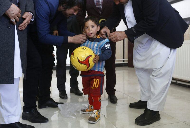 Five year-old Murtaza Ahmadi wears a shirt of Barcelona's star Lionel Messi made of a plastic bag at the Afghan Football Federation headquarters in Kabul, Afghanistan February 2, 2016. Barcelona star Lionel Messi will meet an Afghan boy who gained Internet fame after a touching series of photographs went viral, showing him playing in a shirt improvised from a plastic bag and bearing the name and playing number of his hero. REUTERS/Omar Sobhani