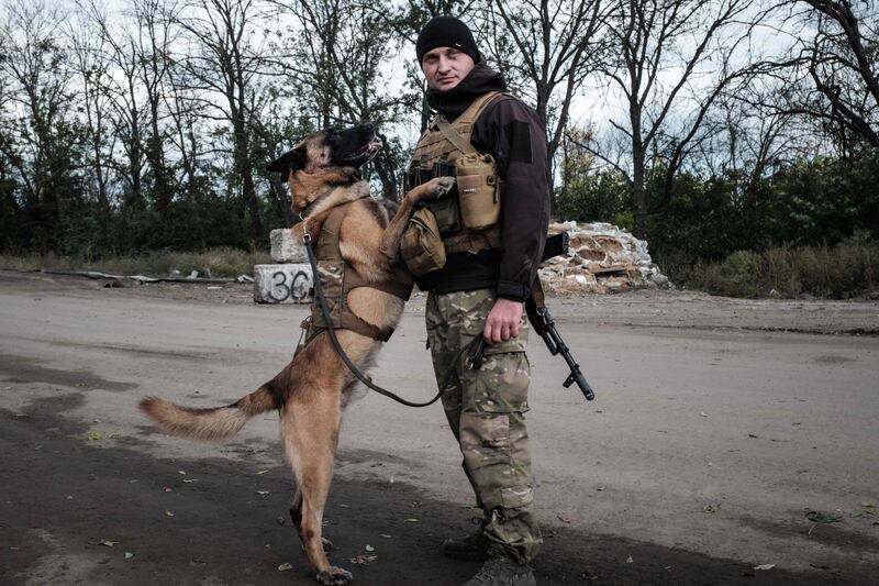 Andriy Symchuk, a police officer in Lviv, and his sniffer dog Bars at a checkpoint in Izyum, Kharkiv. AFP