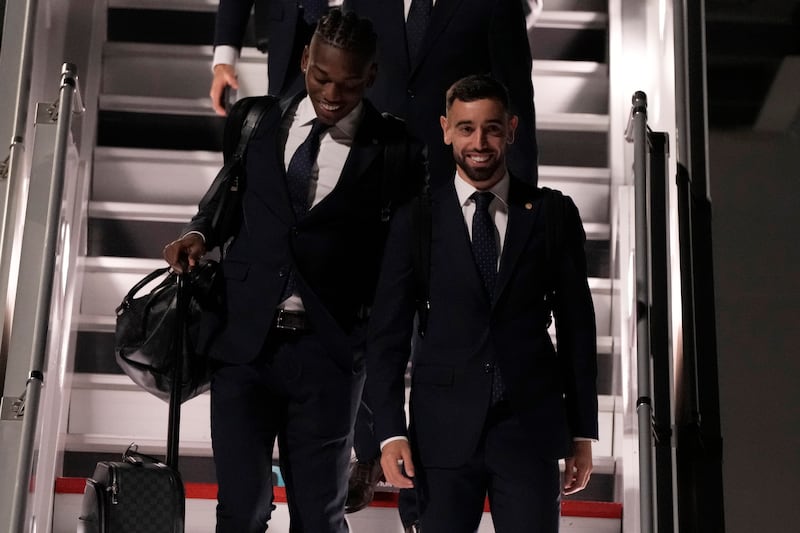 Bruno Fernandes, right, arrives in Doha with teammates at the Hamad International Airport. AP