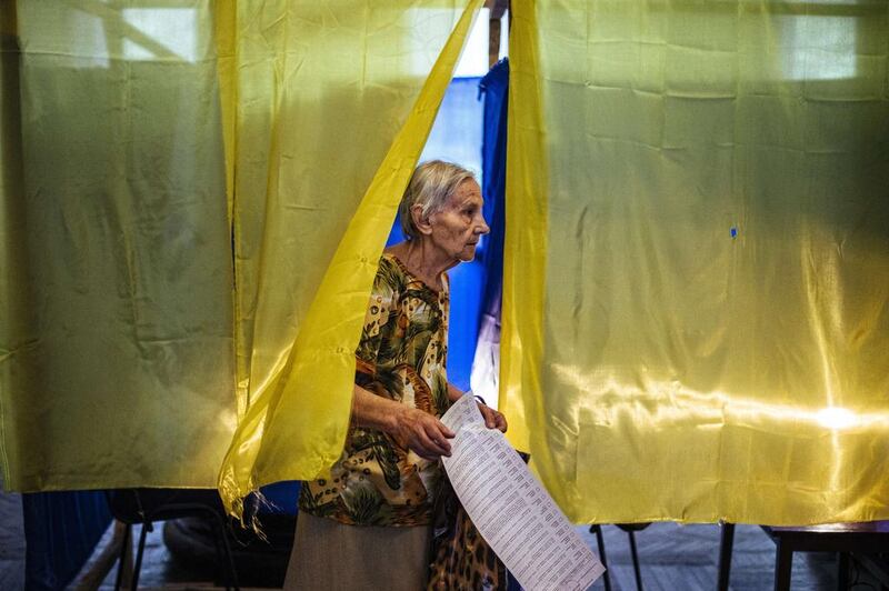 A woman holds her ballot as she leaves a polling station in the eastern Ukrainian town of Dobropillya on May 25, 2014. Dimitar Dilkoff/AFP Photo