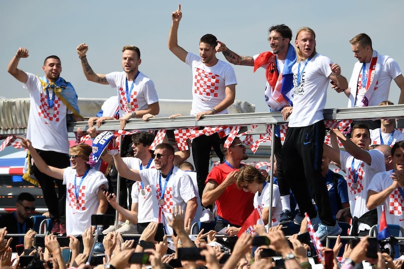 Croatian national football team members ride an open-roof coach in the Zagreb international airport. Attila Kisbenedek / AFP