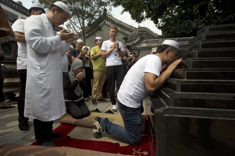 Muslim pray before the Shaykhs tombs, relics from the 13th century, after Eid Al Fitr prayers at the Niujie mosque in Beijing. Ng Han Guan / AP Photo