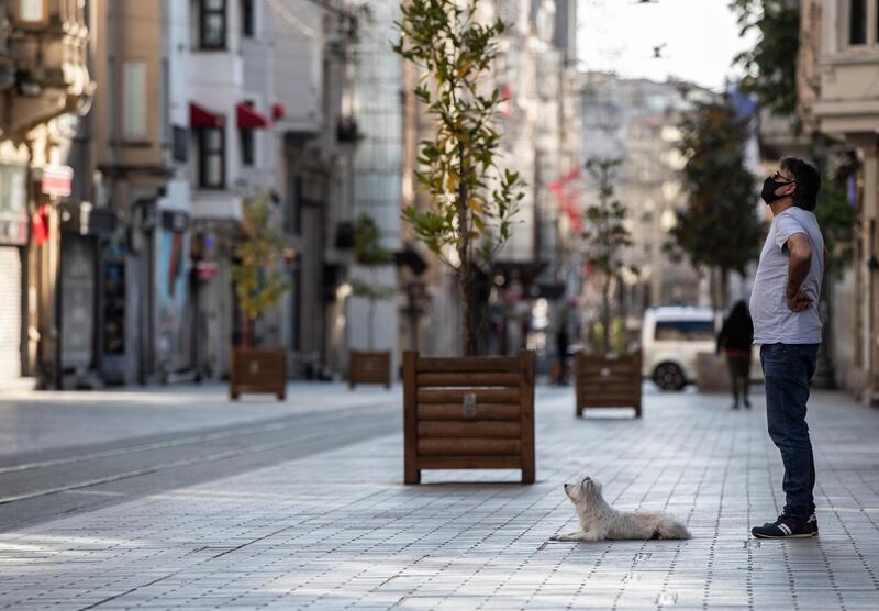 A man and his dog stand on an empty street during curfew in Istanbul, Turkey.  EPA