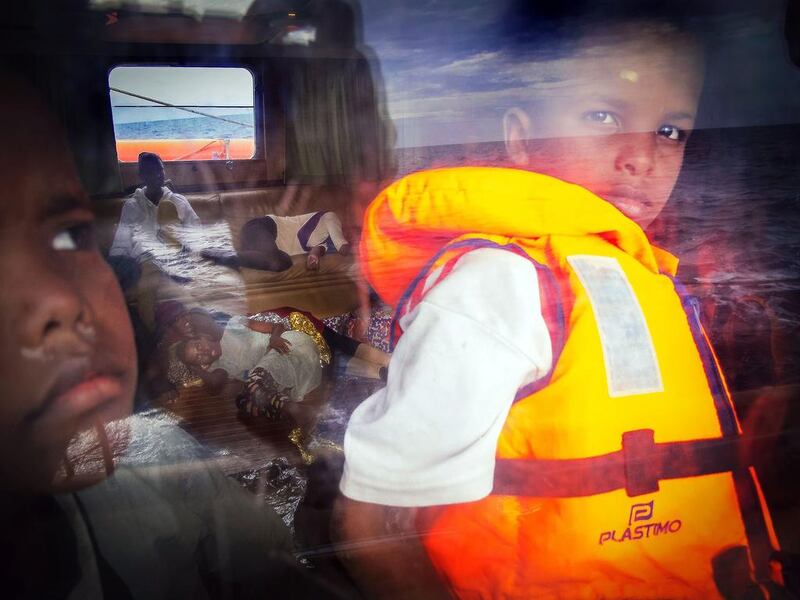 Eight-year-old Samir, right, from Somalia, looks out of the window of the Astral rescue ship from the non-governmental organisation Proactiva Open Arms, while others rest as they head towards the Italian island of Lampedusa in a storm of 35 knots after they were rescued at sea. Libya with its 1,770 kilometres of coastline has become a hub of illegal immigration towards Europe in the absence of proper border controls in a country plunged into chaos. Migrants head in rickety makeshift boats for the Italian island of Lampedusa some 300 kilometres off the coast. Ricardo Garcia Vilanova / AFP