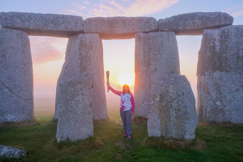 Sally Orange carries the baton at Stonehenge. Getty Images