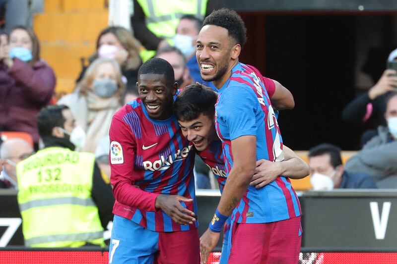 Barcelona's Spanish midfielder Pedri, centre, celebrates with teammates Ousmane Dembele and Pierre-Emerick Aubameyang after scoring against Valencia. The goal was later attributed to Aubameyang. AFP